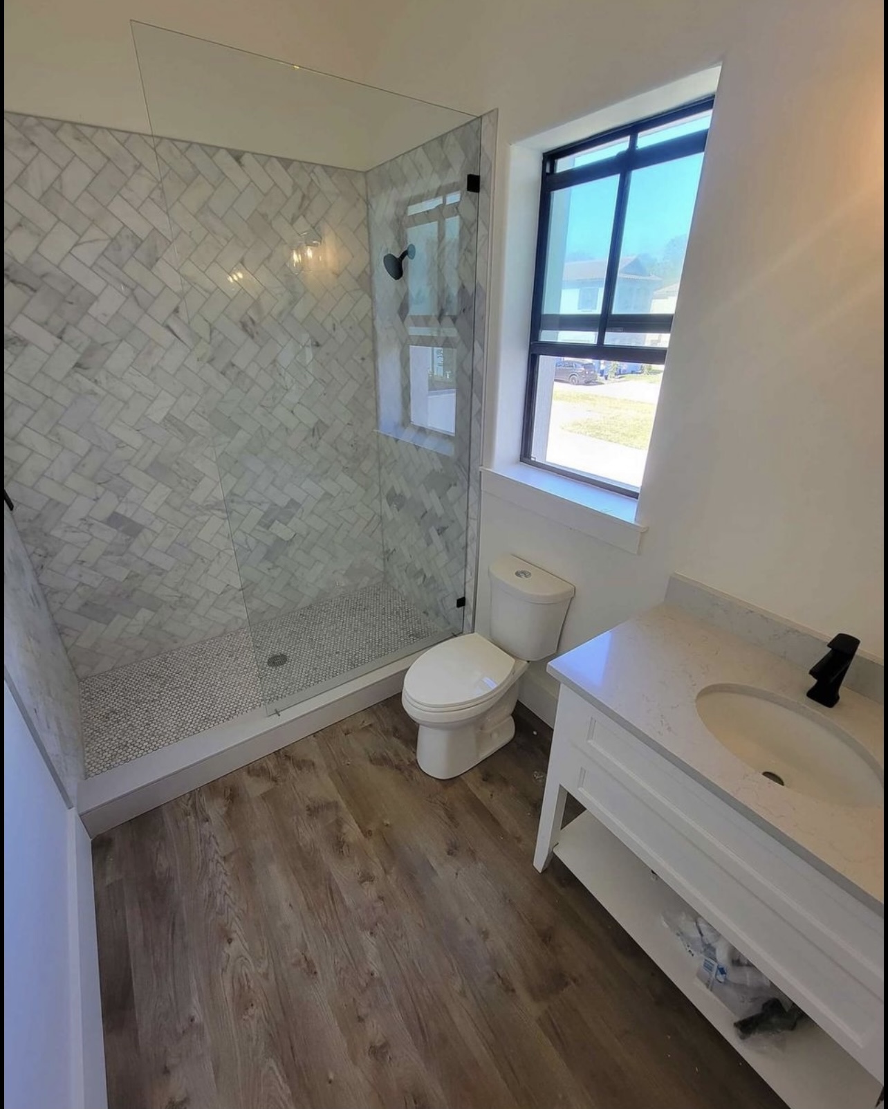White herringbone tile in a light filled bathroom