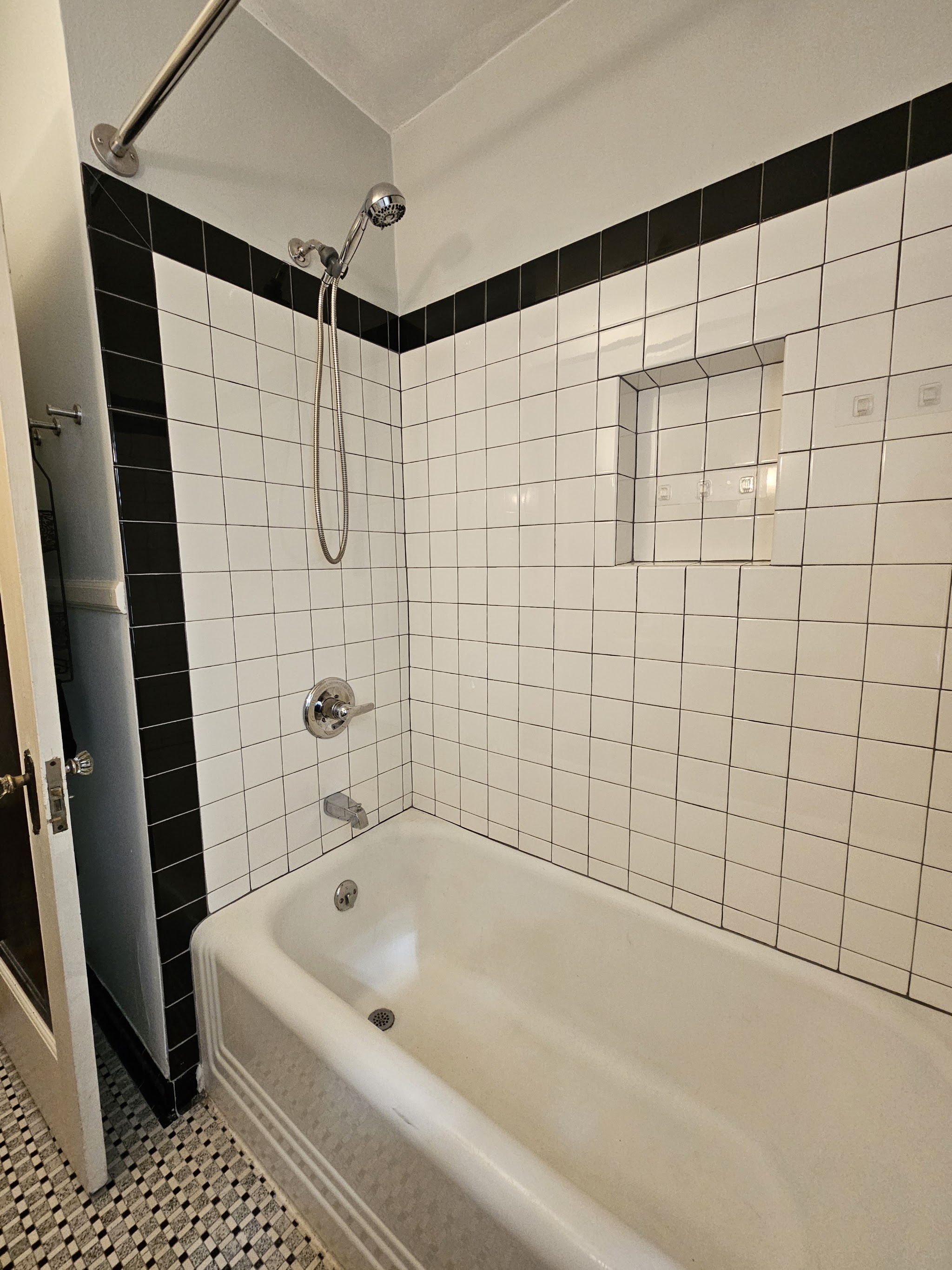 Classic black and white tiled bathtub surround